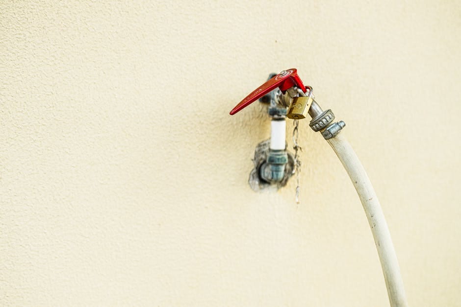 Plumber connecting a garden hose to a water heater drain valve for a flush in Fort Myers