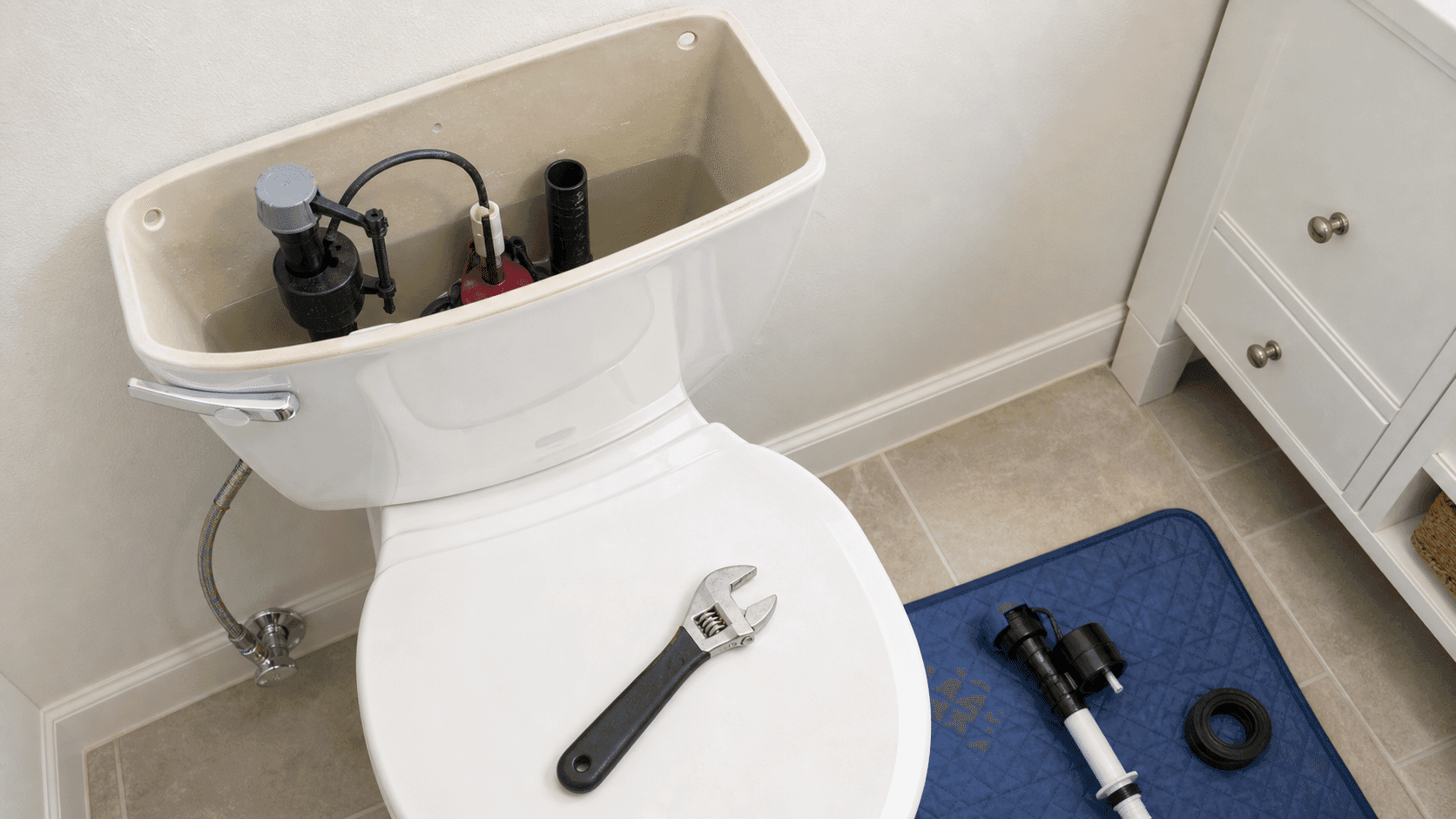 Toilet repair diagnostic setup with replacement fill valve and plumbing tools