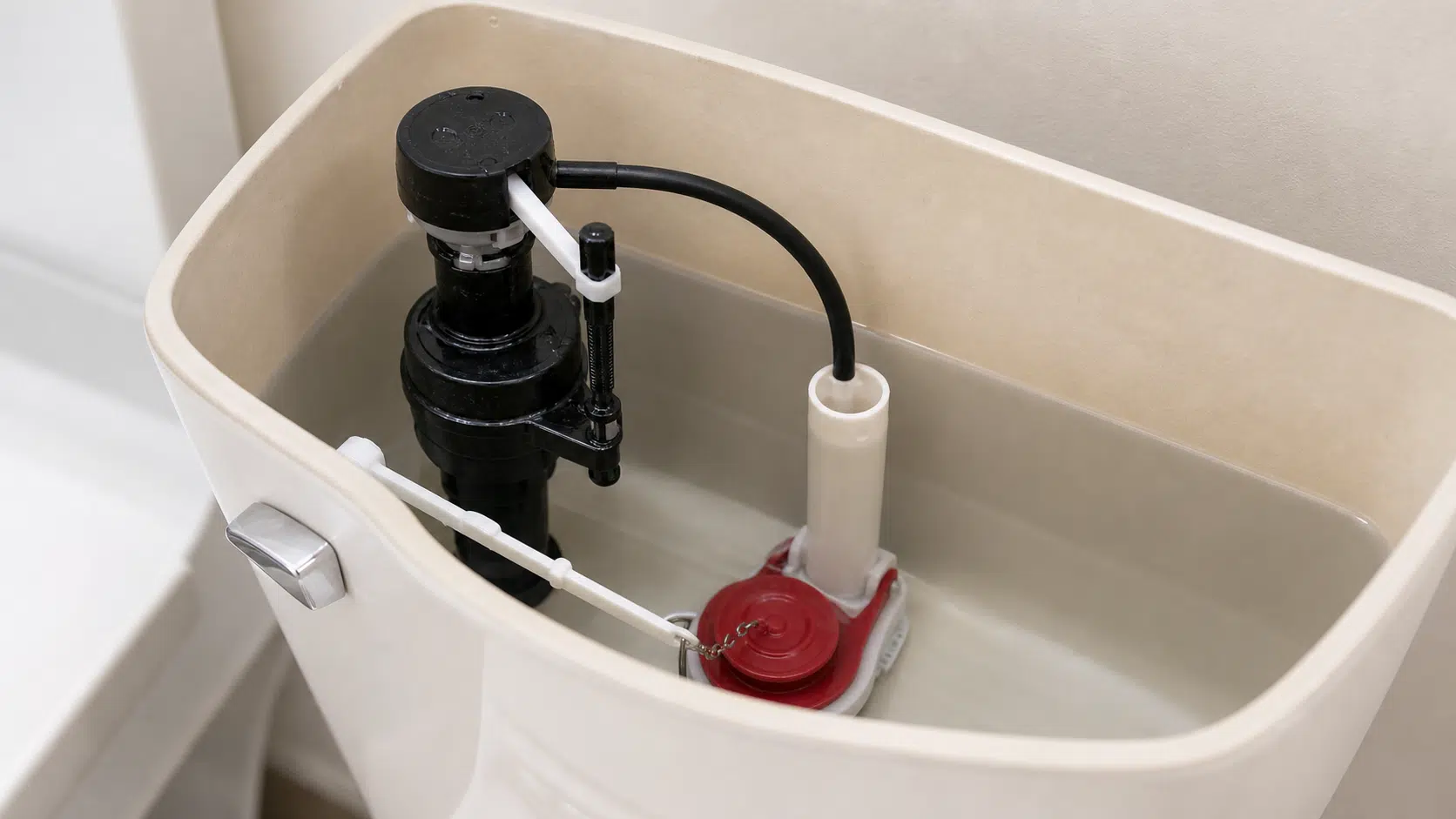 Toilet tank interior showing flapper fill valve and overflow tube components