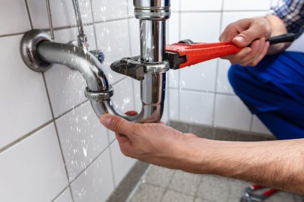 Maleplumbershandrepairingsinkpipeleakagewithadjustablewrench - Leak Repair Services Fort Myers FL | Waterway Plumbing