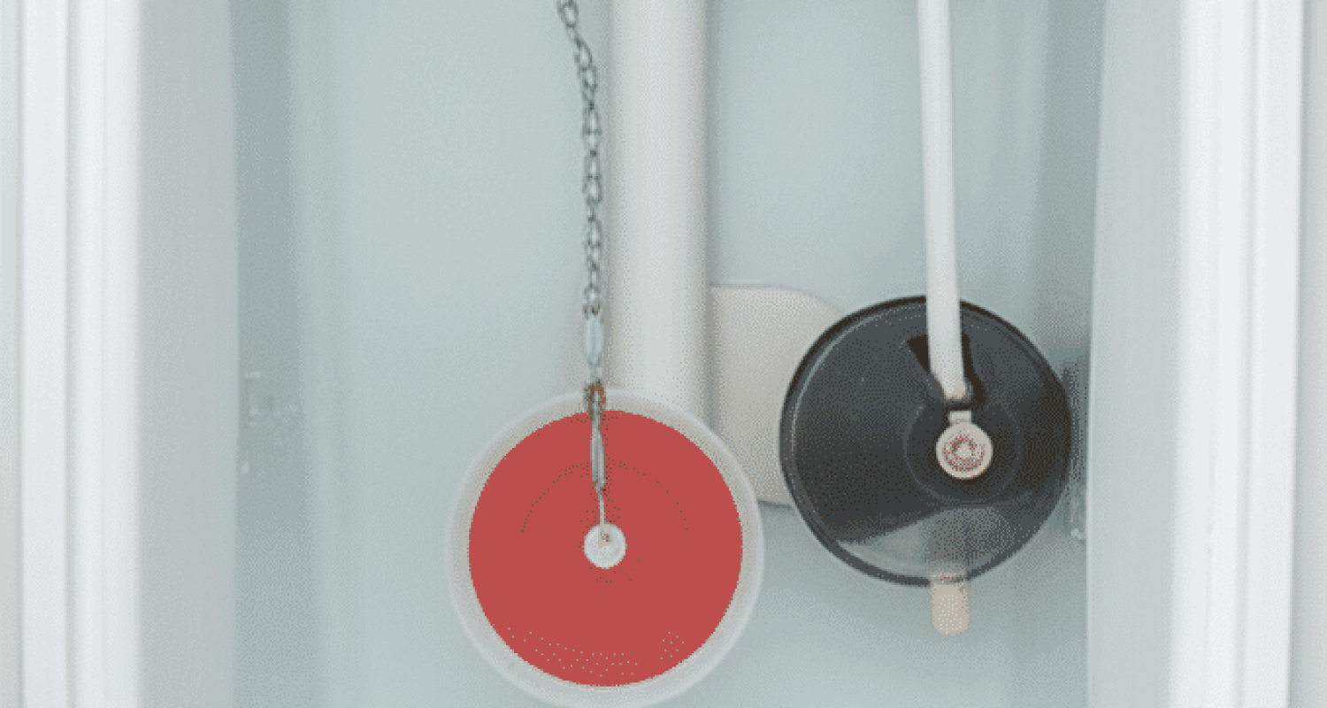 Inside view of toilet tank showing flapper valve fill valve overflow tube and chain mechanism